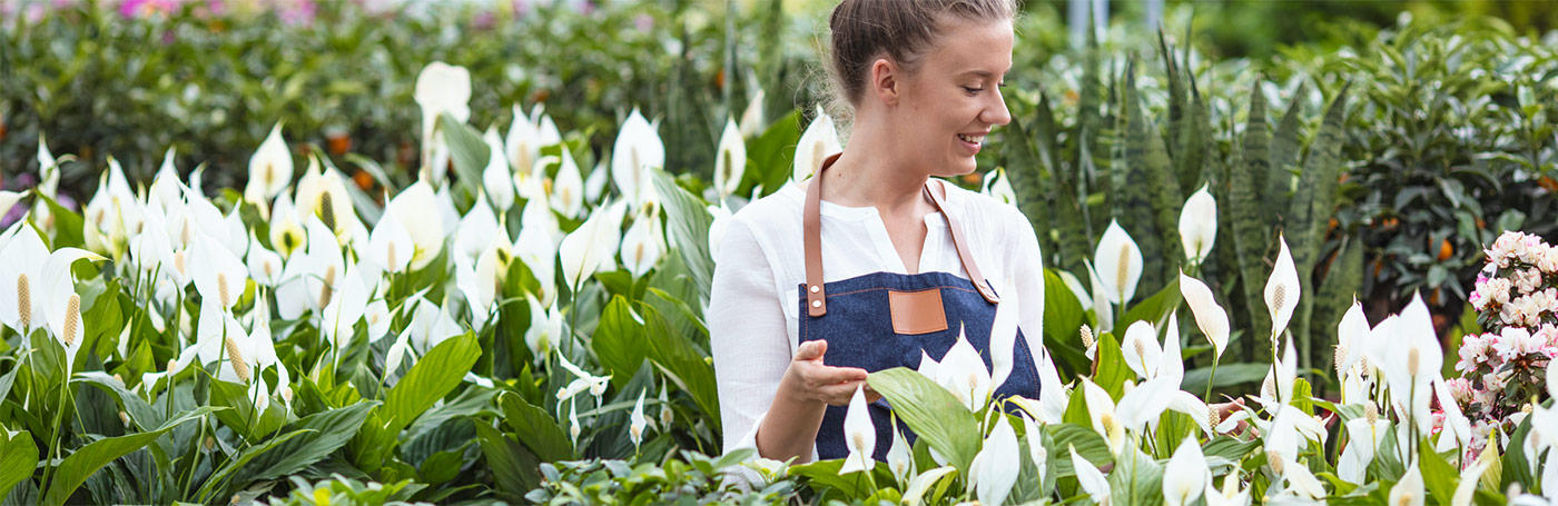 A woman smiling while in the flower garden | Careers Collectiv