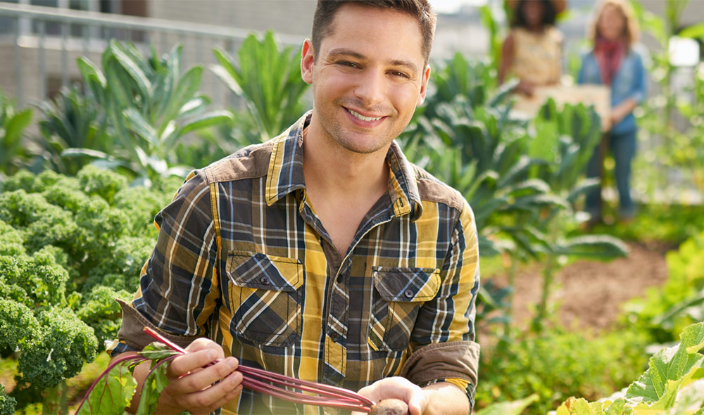 A man smiling while carrying his vegetable | Careers Collectiv