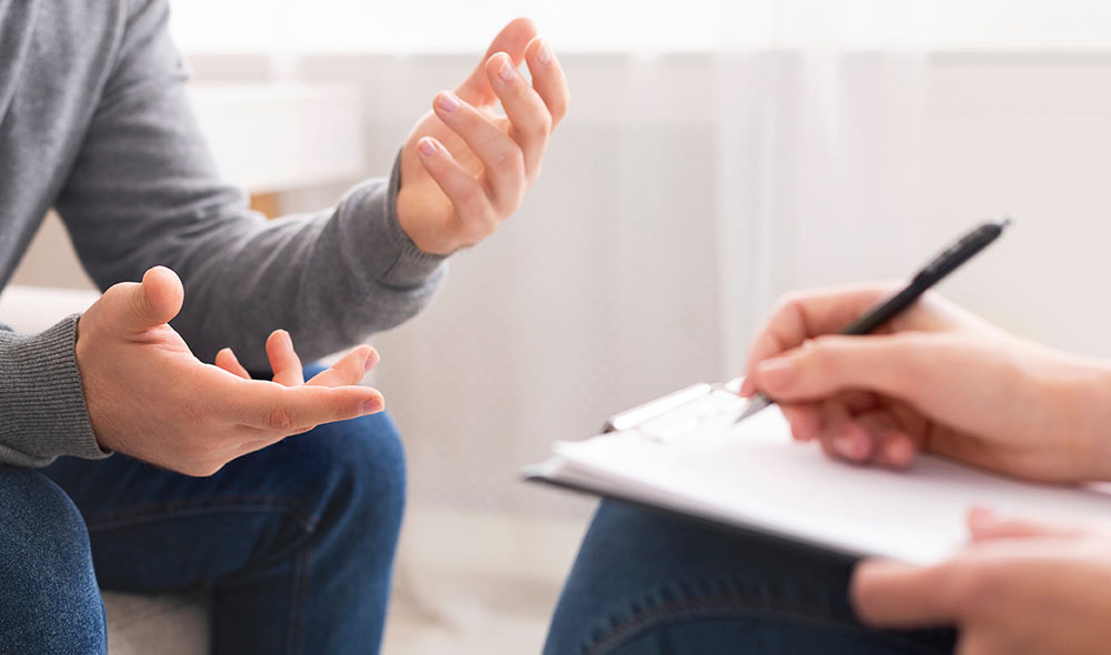 Two people having counselling with hand gestures | Careers Collectiv