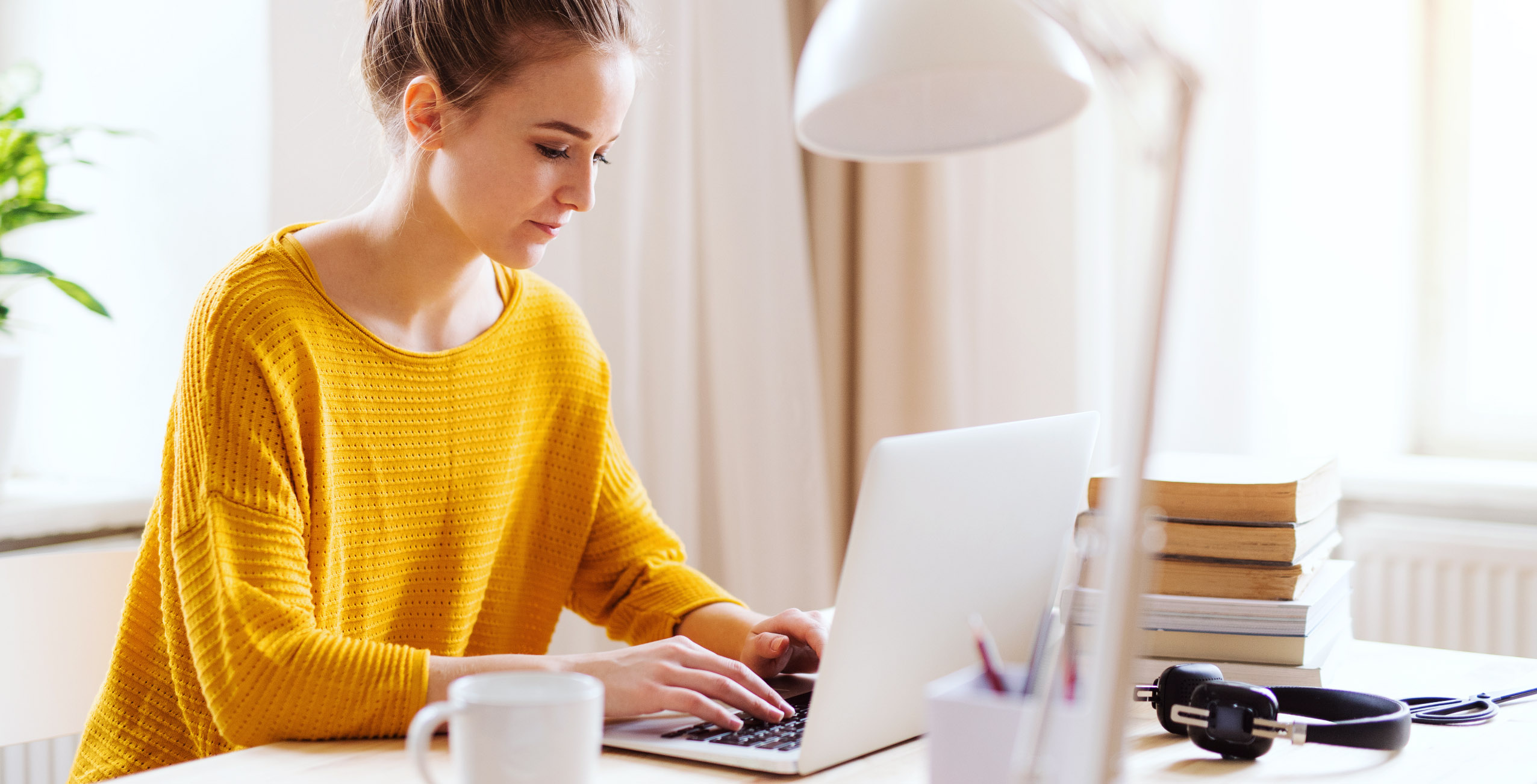 A girl in yellow shirt typing on her laptop | Careers Collectiv