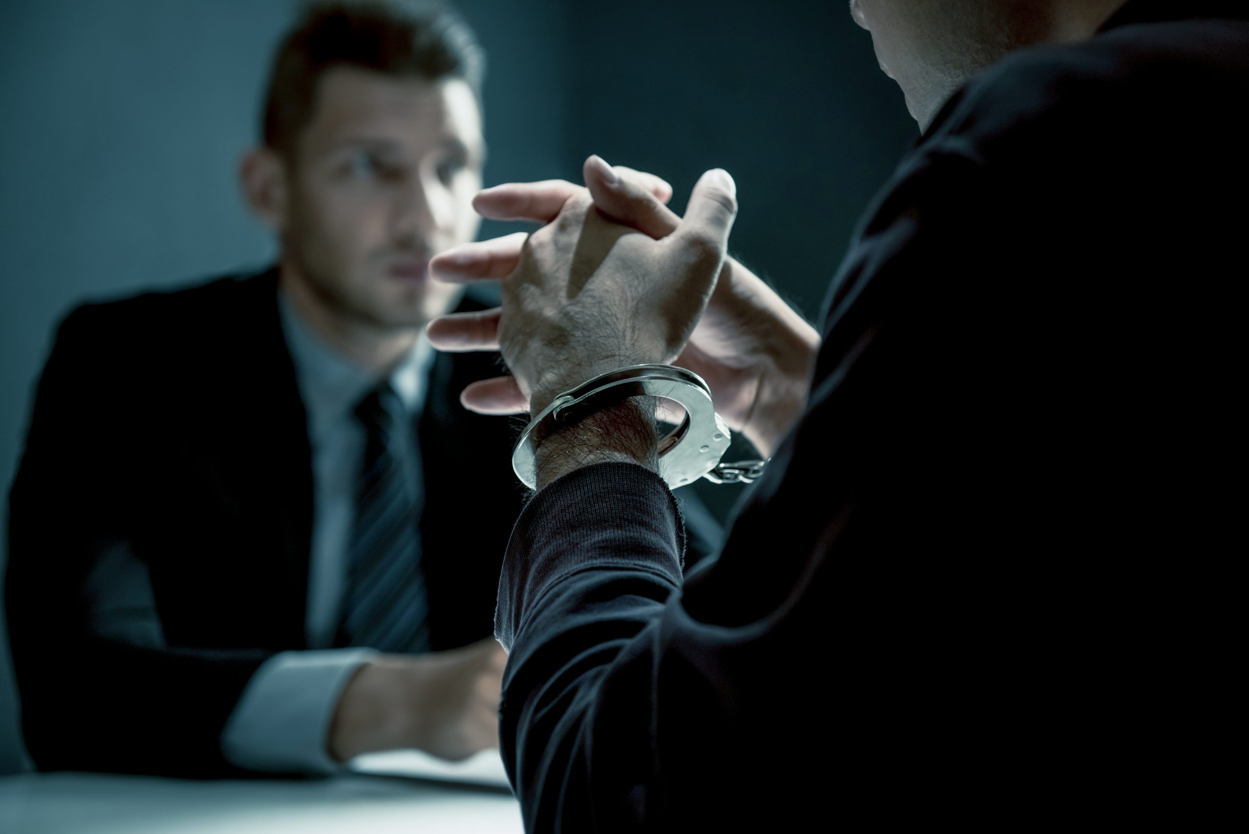 Criminal man with handcuffs being interviewed | Careers Collectiv